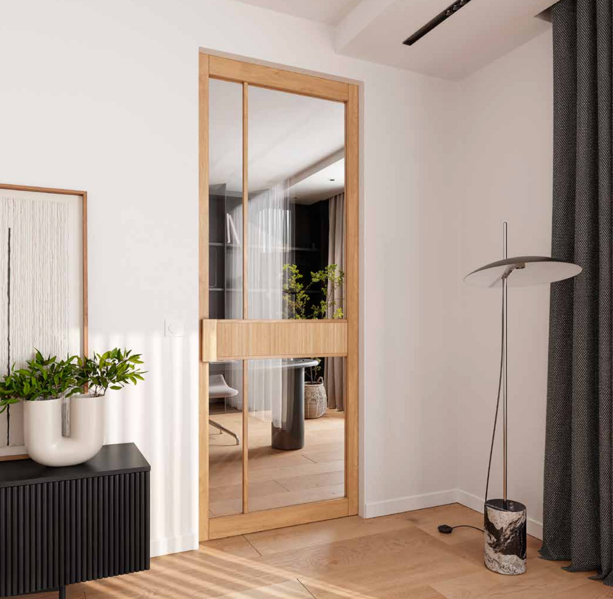 A modern interior space featuring a light oak wood sliding glass door with a horizontal wood divider, set in a minimalist room with white walls, a black ribbed sideboard, and a floor lamp.